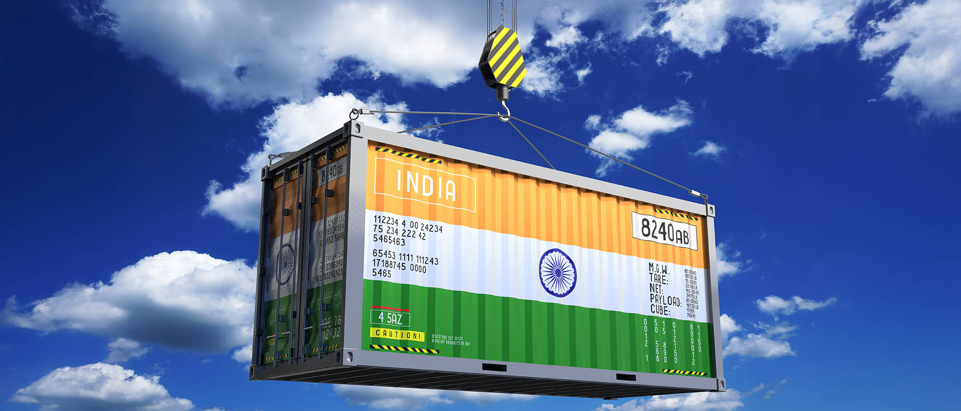 Shipping container marked India suspended from a crane hook