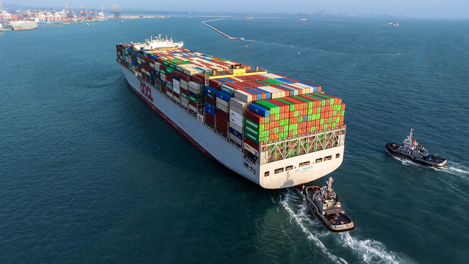 Container ship being escorted by tugs on approach to port